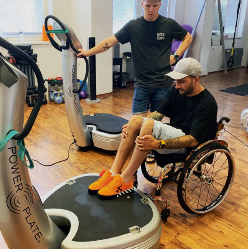 bekim sitting on wheelchair while using Power Plate proMotion