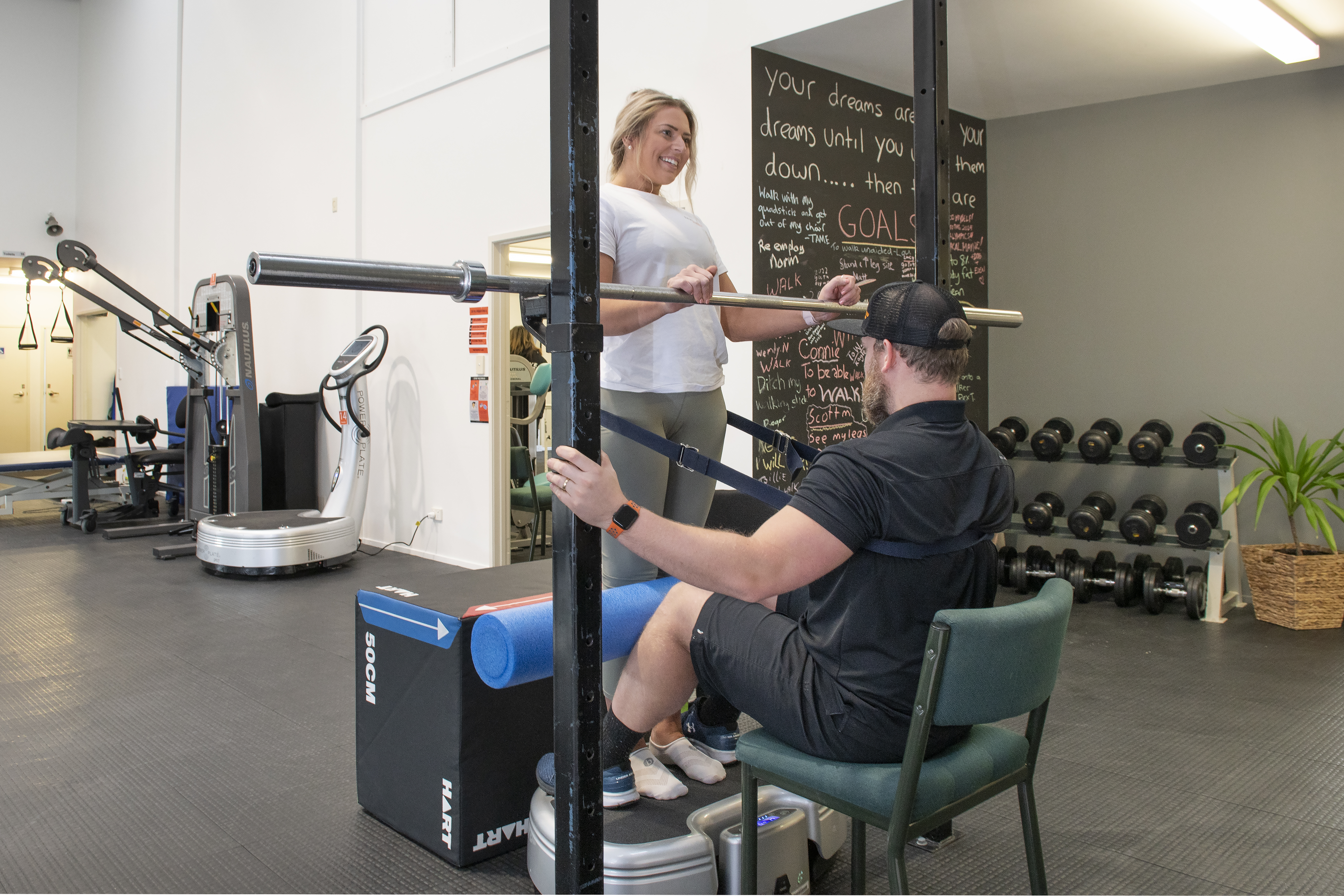 Casey standing using Power Plate while holding equipment