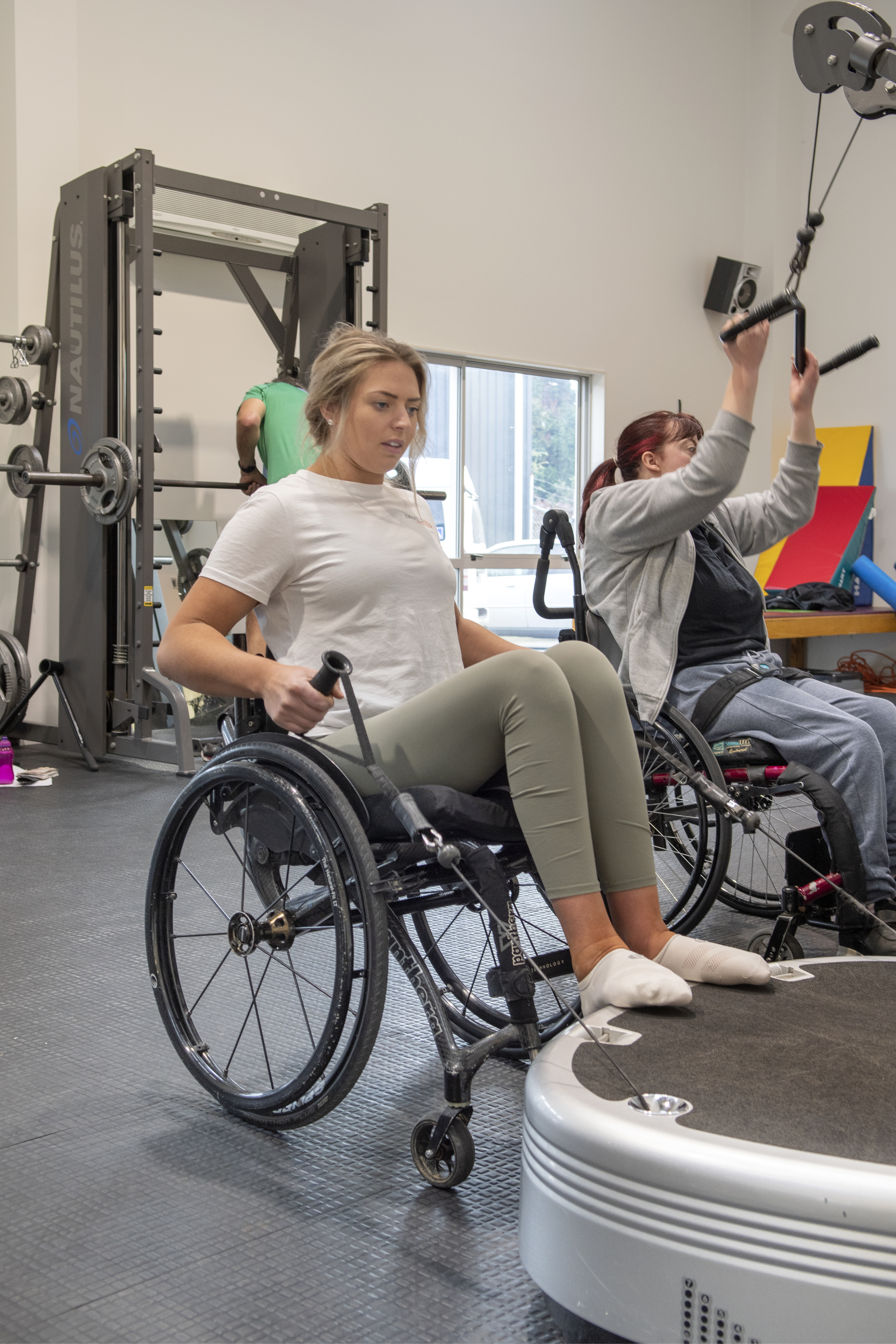 Casey sitting on wheelchair while using Power Plate proMotion